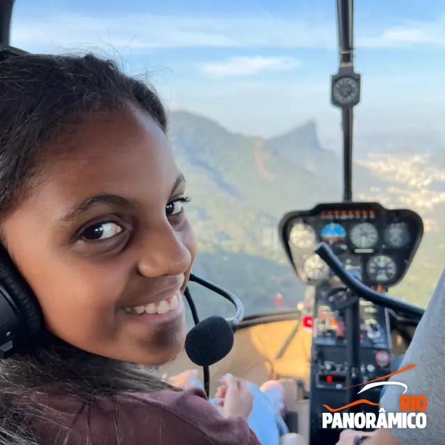 Passageira sorrindo no helicóptero com a cidade ao fundo