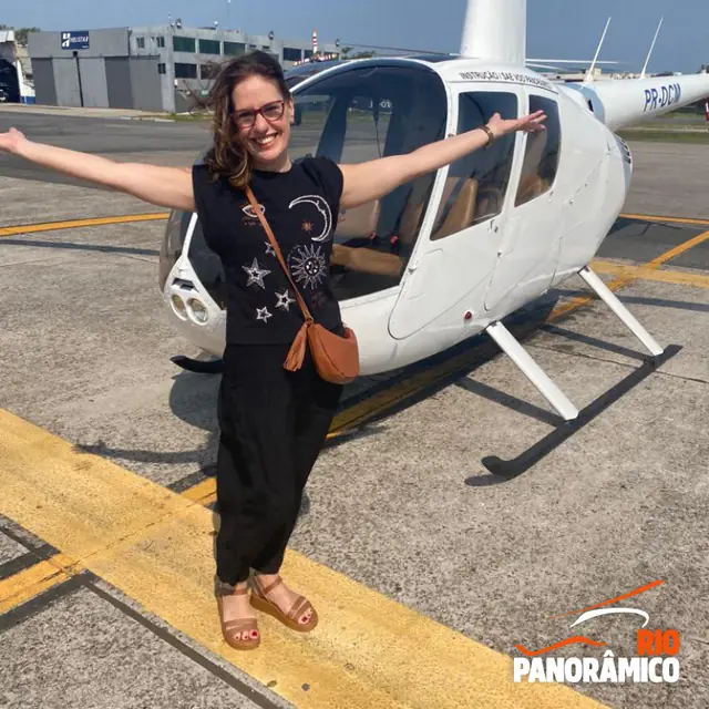 Passageira ao lado do helicóptero no heliponto